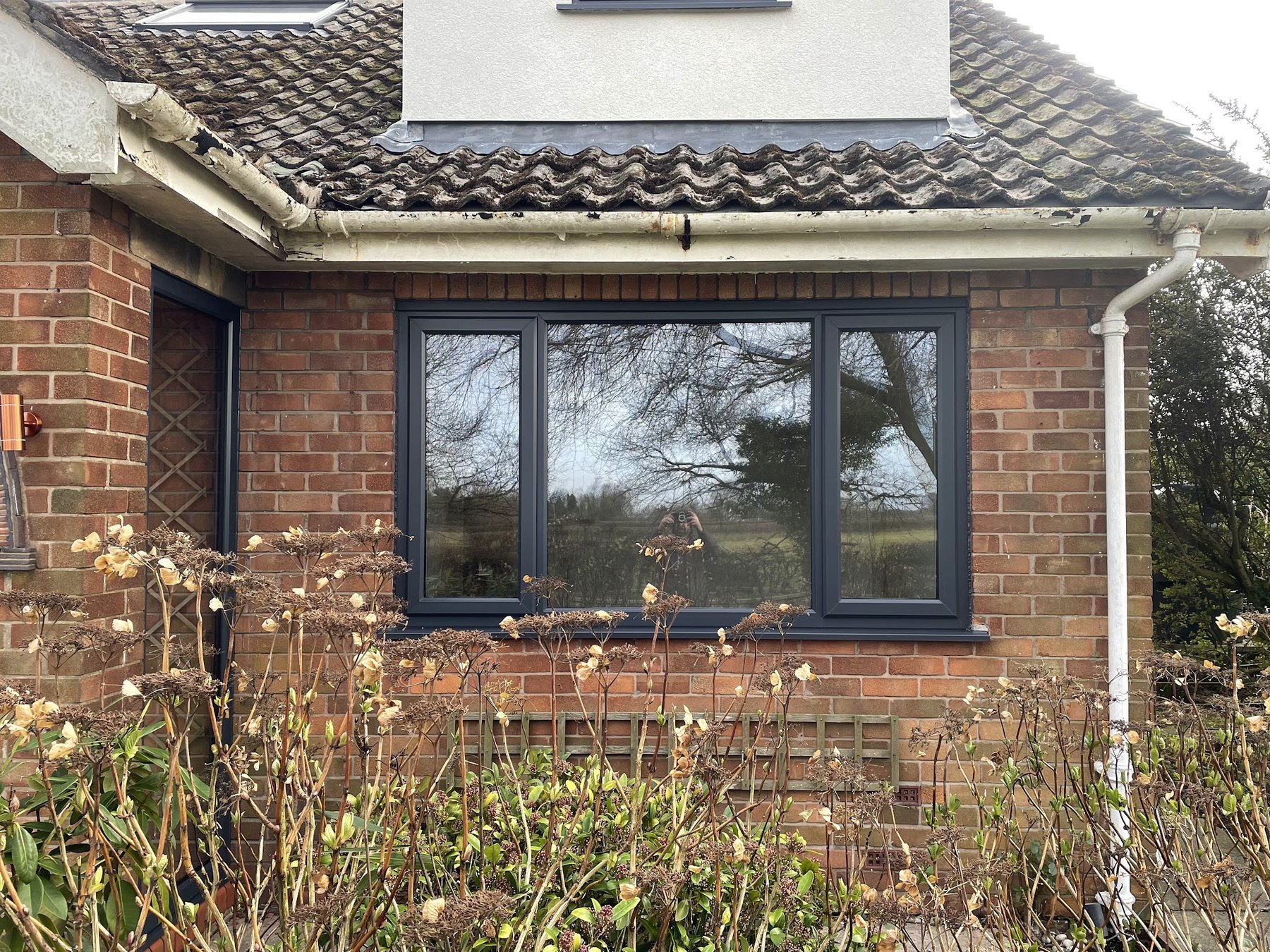 An anthracite grey window in the front of a brick bungalow