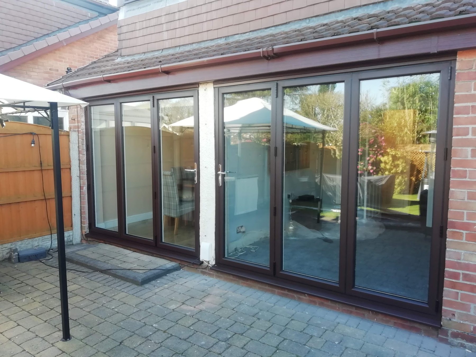 Brown patio doors running across the back of an extension